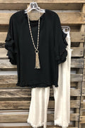 Camisa lisa negra con cuello redondo, manga corta y volantes